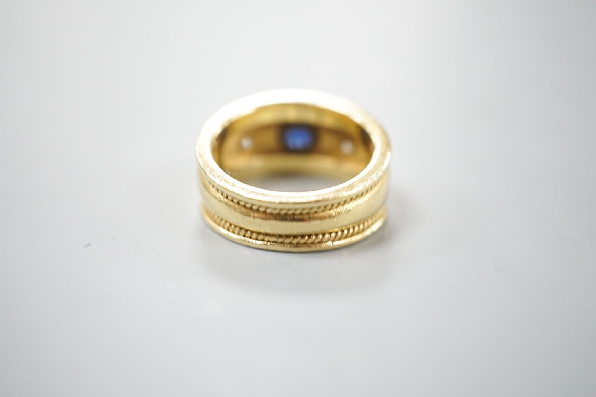 A modern yellow metal and collet set sapphire and diamond three stone ring, signed Charles Greig, size M, gross weight 11.5 grams.